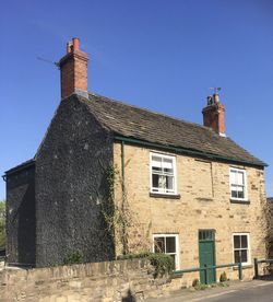 Low angle view of old building against clear blue sky