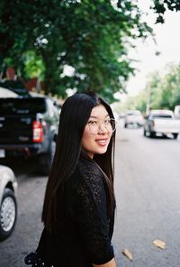 Portrait of young woman in car on road in city