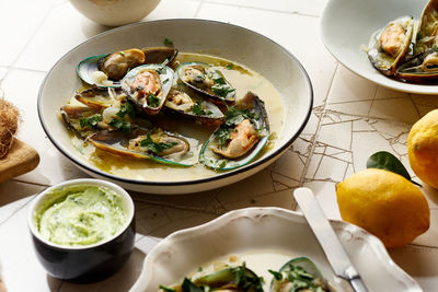 Cooked kiwi green mussels with wine, garlic and parsley served with baguette and butter with herbs