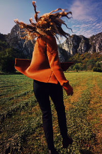 Rear view of woman standing on field