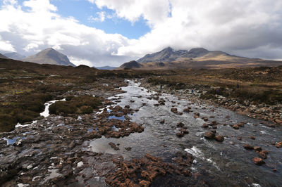 Scenic view of river stream and mountains at skye against sky