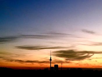 Silhouette of communications tower at sunset