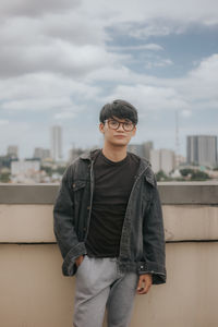 Full length of young man standing against sky