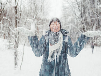 Woman standing on snow covered field