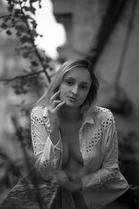 Portrait of woman in fully unbuttoned shirt outdoors
