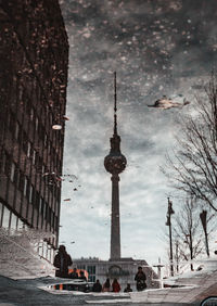 Buildings in city against cloudy sky