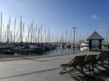 Boats moored at harbor against sky