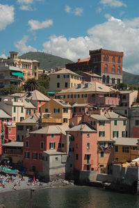 Houses by sea against sky in town