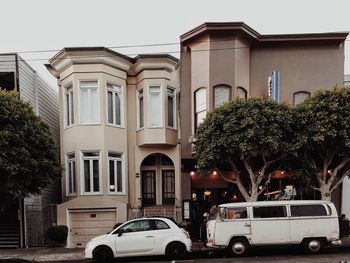 Cars on city street against sky