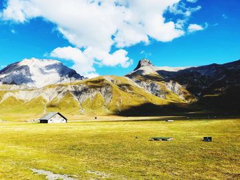 Scenic view of field and mountains against sky