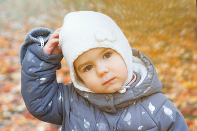 Portrait of little caucasian girl on background of autumn leaves.