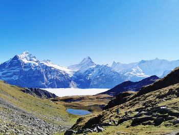 Scenic view of snowcapped mountains against clear blue sky