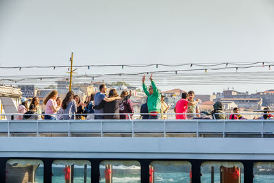 People on bridge against clear sky