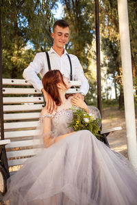 Wedding couple in the woods on a white swing. young people in love love with each other.