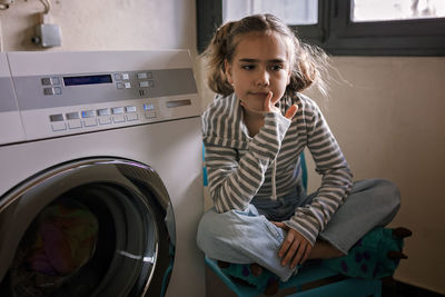 Teenage girl using common laundry to save resources and money. sustainability and environment care