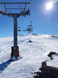Ski lift on snow field against sky