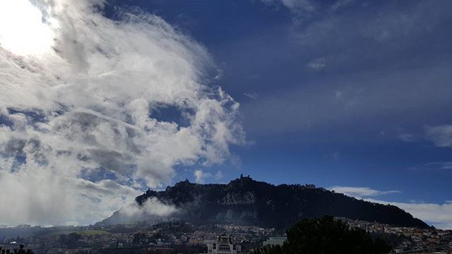 mountain, sky, building exterior, cloud - sky, built structure, architecture, scenics, beauty in nature, mountain range, landscape, nature, blue, cloud, day, cloudy, outdoors, city, travel destinations, cityscape, no people