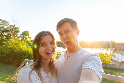 Portrait of smiling couple against sky