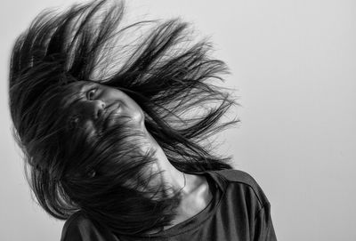 Close-up portrait of a woman against white background