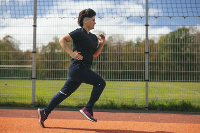 Young woman jogging at outdoor gym