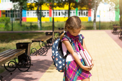 Girl looking away while sitting on bench