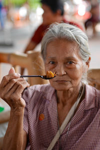 Portrait of senior woman eating food