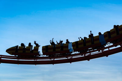 Group of people in row against blue sky