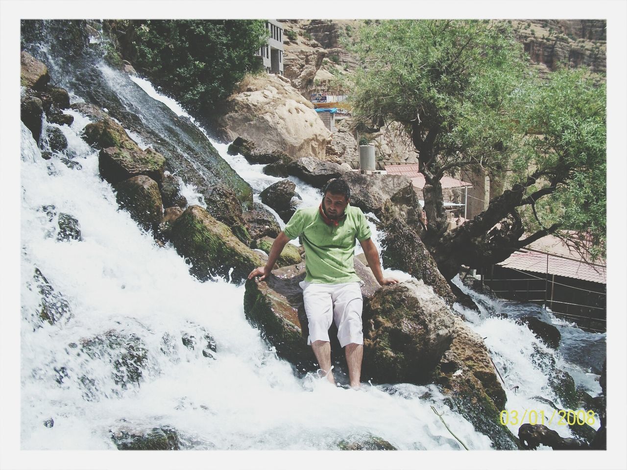 winter, snow, lifestyles, cold temperature, leisure activity, season, rear view, full length, tree, men, transfer print, waterfall, weather, rock - object, water, nature, standing, warm clothing