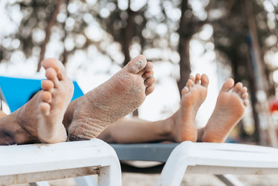 Low section of couple relaxing on beach