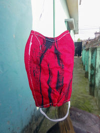 Close-up of red heart shape hanging against wall