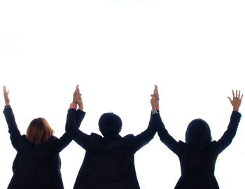 Rear view of people standing against white background