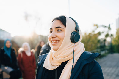 Portrait of smiling young woman standing outdoors