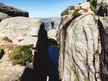 Rear view of man on cliff against sky