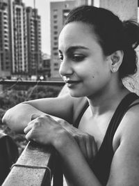 Close-up portrait of young woman sitting in city