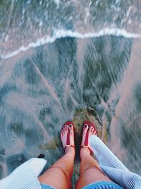 Low section of woman standing in water