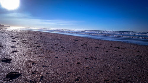 Scenic view of beach against blue sky