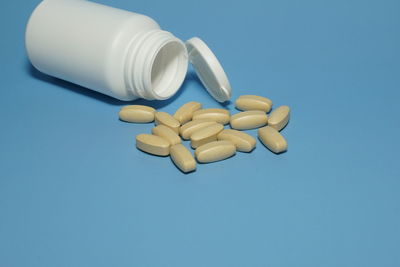 Close-up of white bottle against blue background