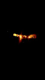 Airplane on illuminated runway against sky at night