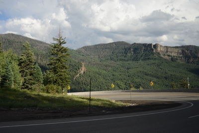 Road by mountains against sky