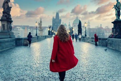 Rear view of women walking on historical building in city