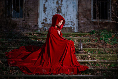 Midsection of woman with red umbrella standing on land