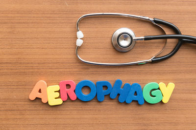 Directly above shot of stethoscope with aerophagy text on wooden table