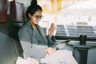 Young girl on the train communicating on the tablet with friends and relatives while traveling 