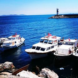 Boats moored on sea against sky