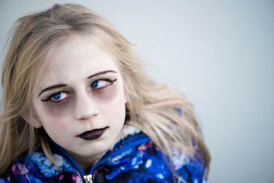 High angle view of girl with halloween make-up against white background