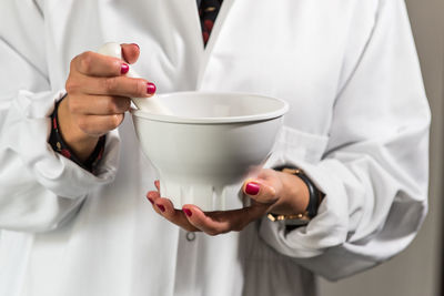 Midsection of man holding mortar and pestle