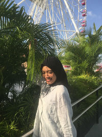 Portrait of young woman with palm trees