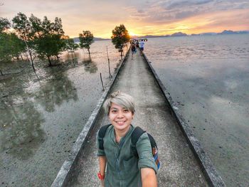 Portrait of smiling mid adult woman against sky during sunset