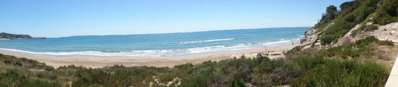 sea, horizon over water, beach, clear sky, water, tranquil scene, scenics, tranquility, blue, beauty in nature, shore, copy space, nature, sand, coastline, idyllic, cliff, vacations, day, incidental people