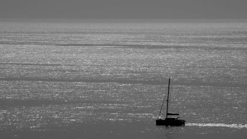 Sailboat sailing in sea against sky